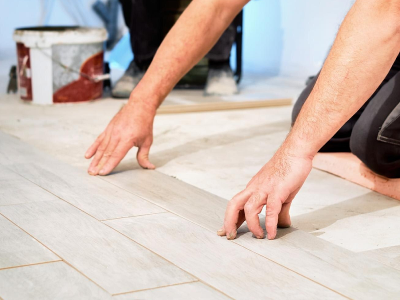 Installing ceramic floor tiles in construction site